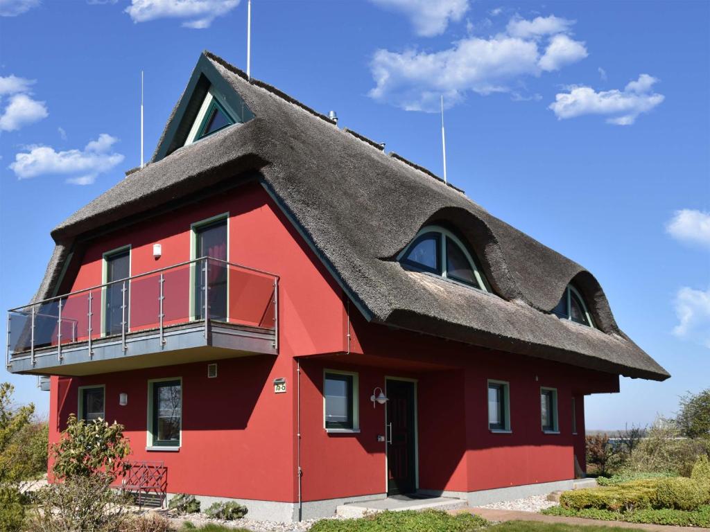 维埃雷格Ferienhaus Boddenbrise mit Hiddenseeblick的茅草屋顶的红色房子