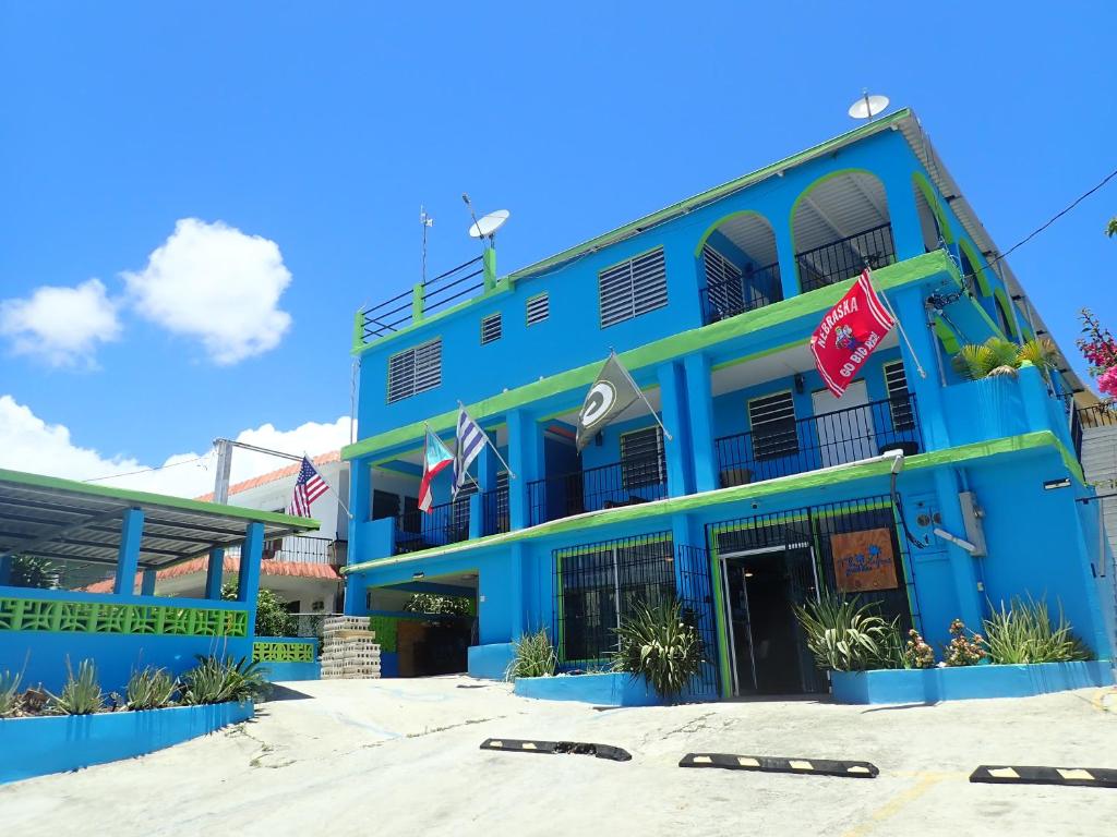别克斯The Vieques Guesthouse的前面有旗帜的蓝色建筑
