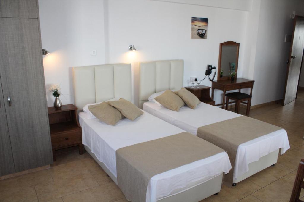 阿依纳帕玛丽亚奇迪利公寓式酒店的酒店客房设有两张床和一张桌子。