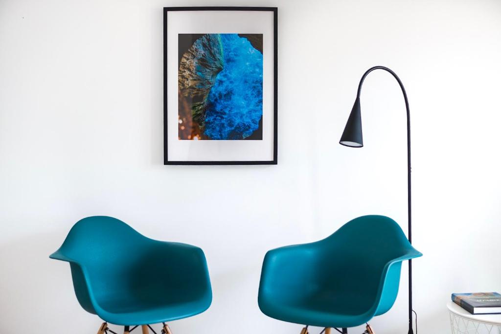 珀彻斯vilamaria apartment的一间设有两把蓝色椅子和一盏灯的房间