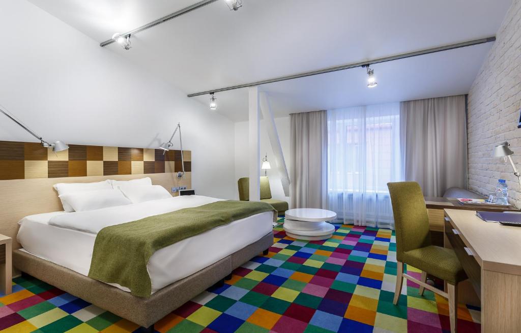 莫斯科塔格斯卡亚斯皮克特尔酒店的酒店客房配有一张床、一张书桌和一张书桌。