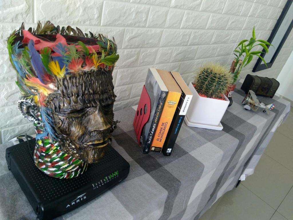 特鲁希略A minutos del centro Con cochera的桌子上一头有书和植物的雕像