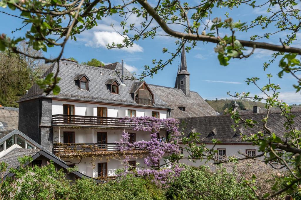 维安登海因茨酒店的一座在前面布满紫色花的建筑