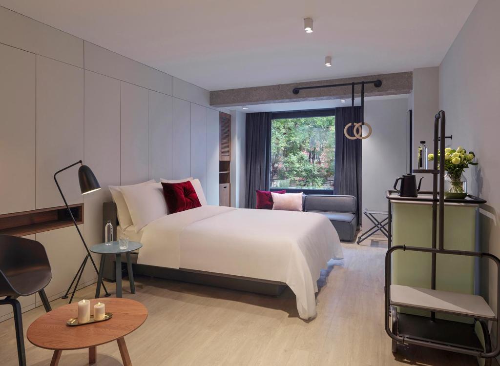 北京Stey Wangfujing Hotel的卧室设有一张白色大床和一扇窗户。