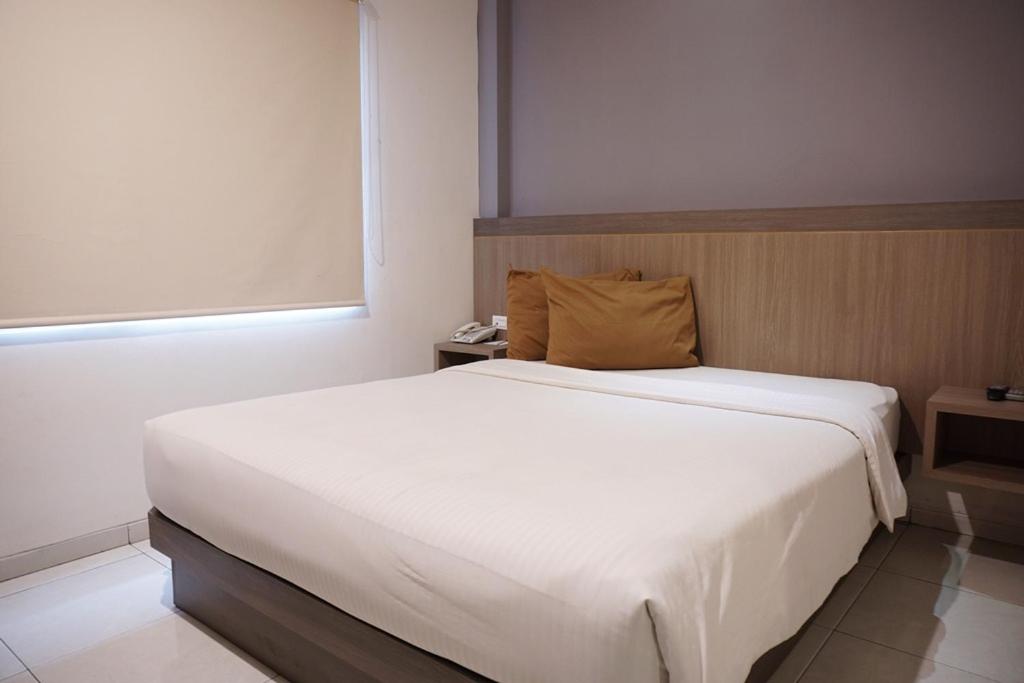 三宝垄Hotel Dalu的卧室配有一张白色大床