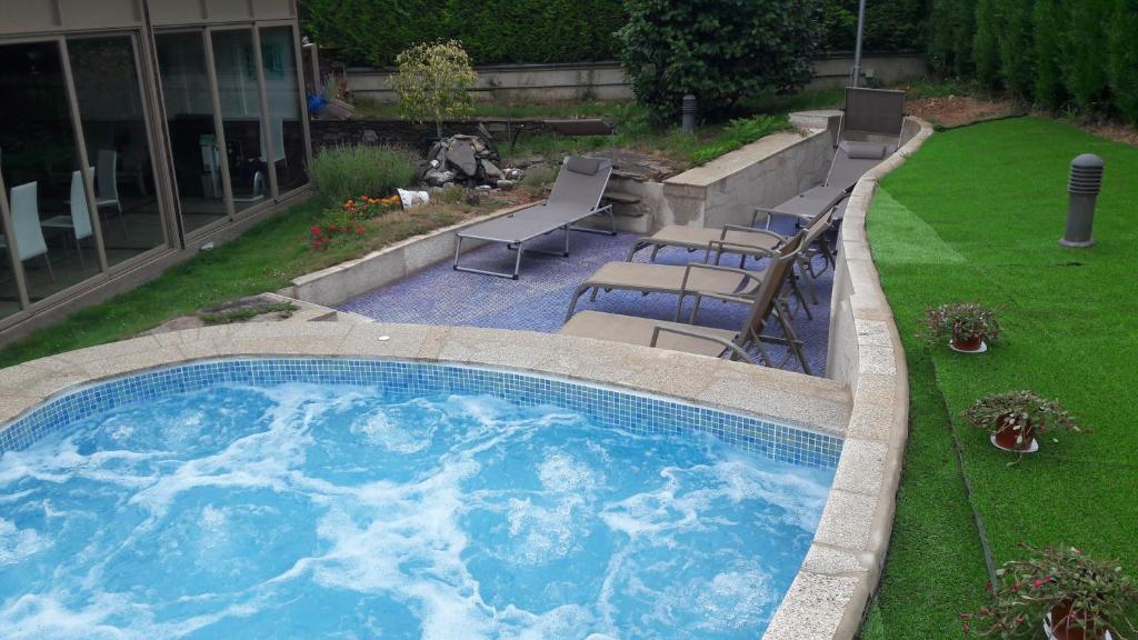 萨尔塞达艾伯格图里蒂科萨塞达酒店的一个带椅子和草坪的大型游泳池