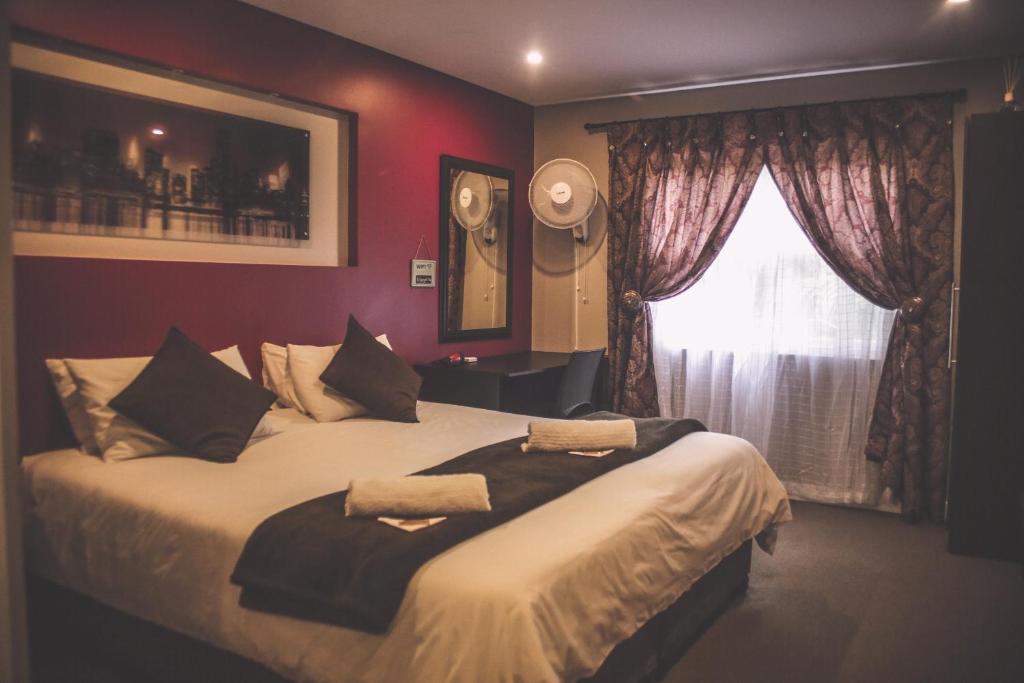 霍维克Biggy Best Boutique Hotel & Self Catering Cottages的一间卧室设有一张大床和一个窗户。
