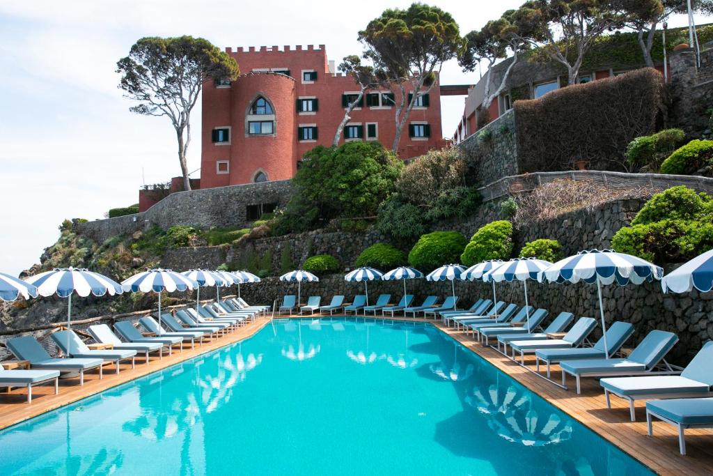 伊斯基亚Mezzatorre Hotel & Thermal Spa的一个带躺椅和遮阳伞的游泳池