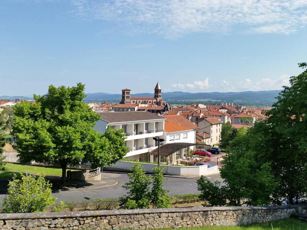 布里尤德Hôtel Poste et Champanne的享有小镇美景,设有一座建筑和树木