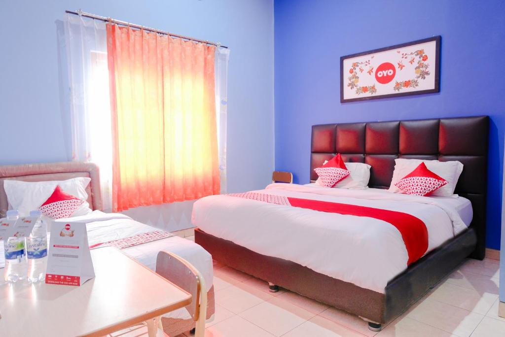 玛琅OYO 778 Guest House Amalia Malang的酒店客房设有一张大床和一张桌子。