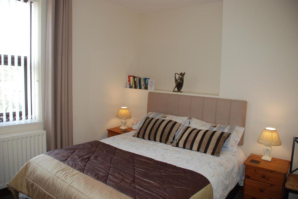 杜伦Apartment Bijou的一间卧室配有一张带两盏灯的床和一扇窗户。