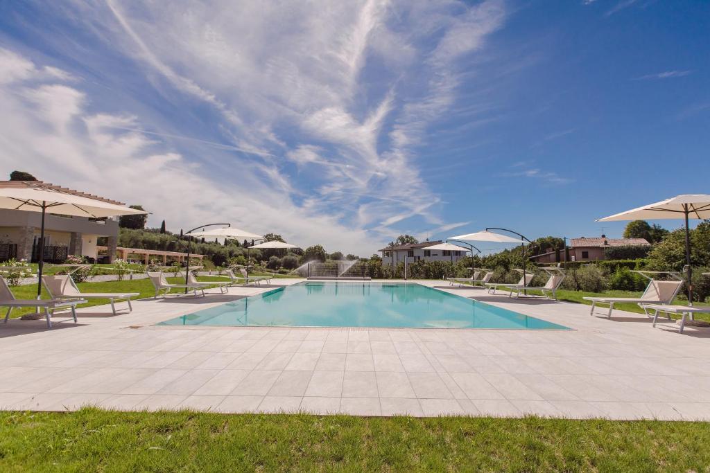 拉齐塞Menta e Rosmarino Rooms的一个带草坪椅和蓝天的游泳池