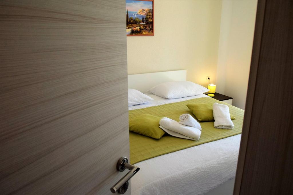 拉布Apartments Kampor的一间卧室配有一张床,上面有两条毛巾