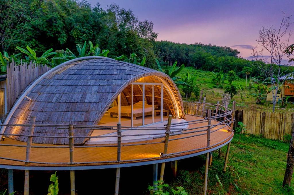 阁遥岛Jaiyen Eco Resort的圆顶房屋,在庭院设有木甲板