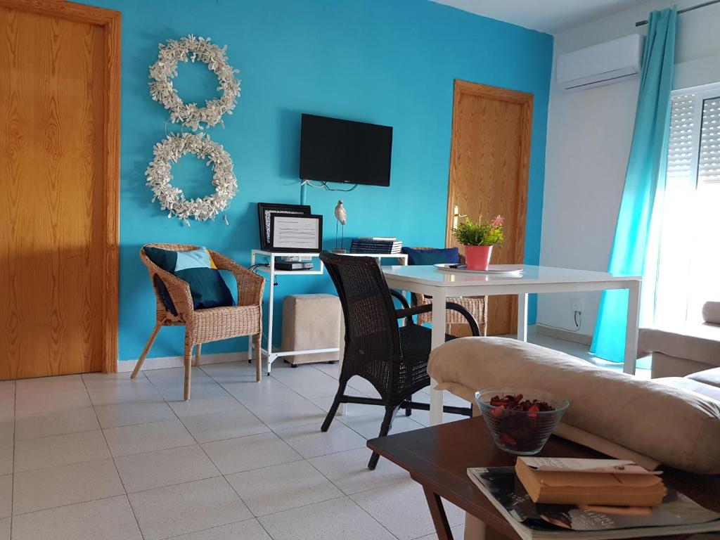 阿亚蒙特Aloja Puerto Deportivo的客厅拥有蓝色的墙壁和桌椅