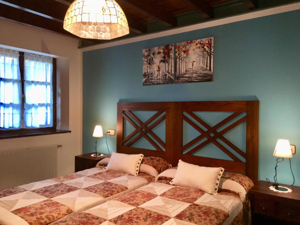 塞洛里奥Apartamentos Palombina的一间卧室配有一张床、两张桌子和两盏灯。