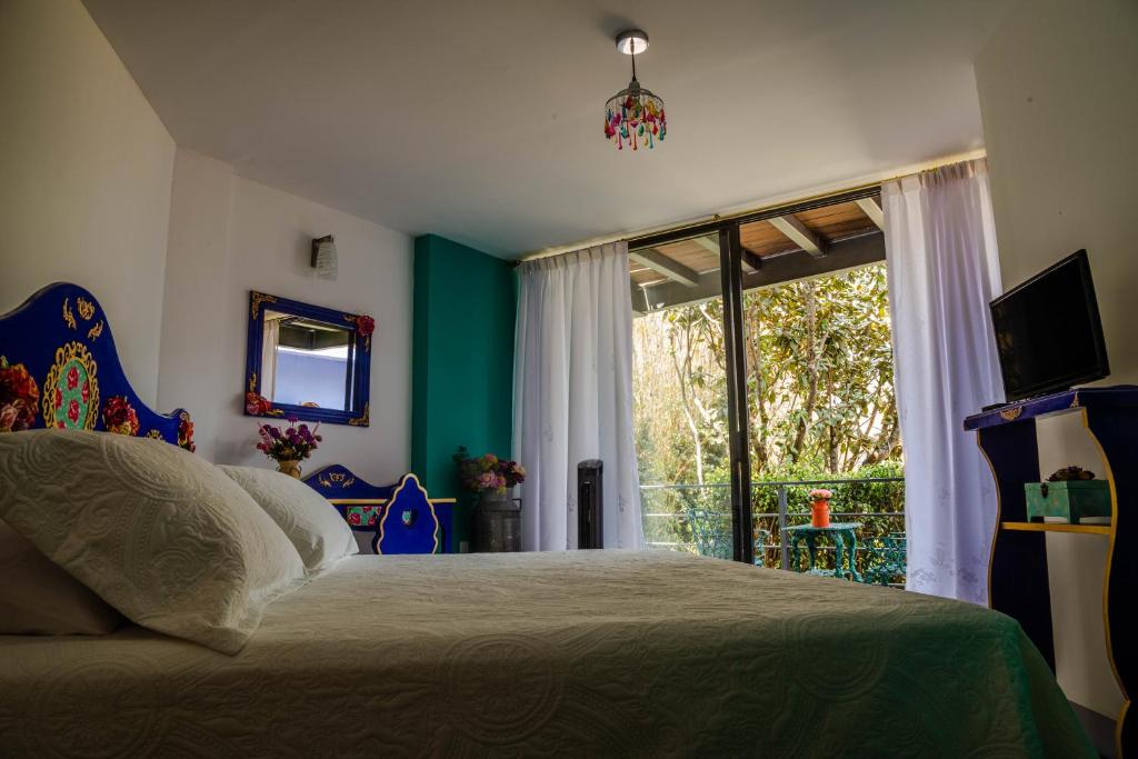 迪坡斯特兰HOTEL EL PAN NUESTRO的一间卧室设有一张床和一个大窗户