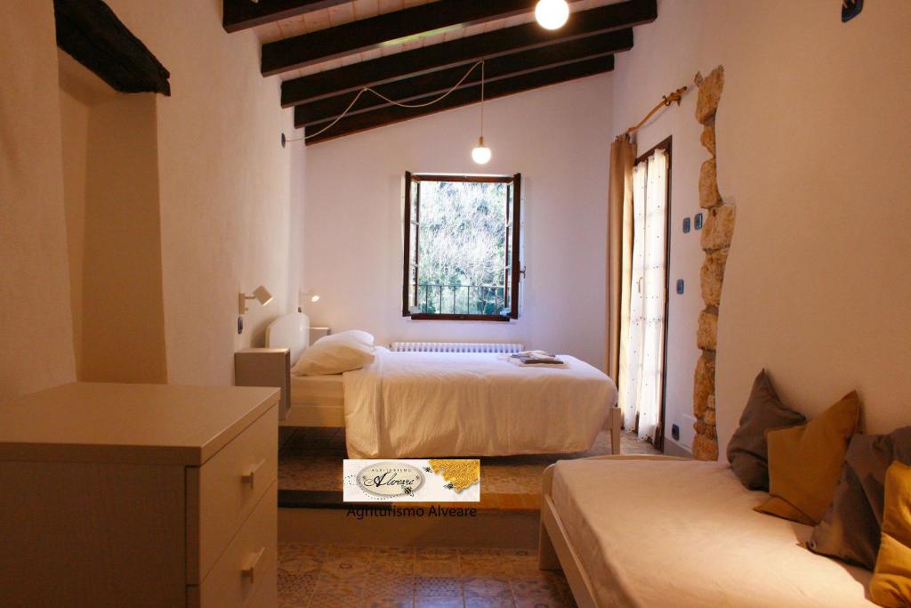 菲纳莱利古雷Agriturismo Alveare的一间卧室设有两张床、一张沙发和一个窗口