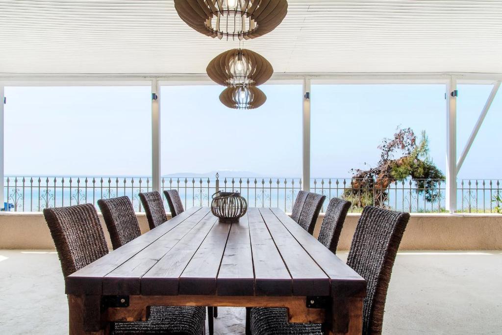尼亚伊拉克利亚Villa Alexandra的一张木桌和椅子,享有海景