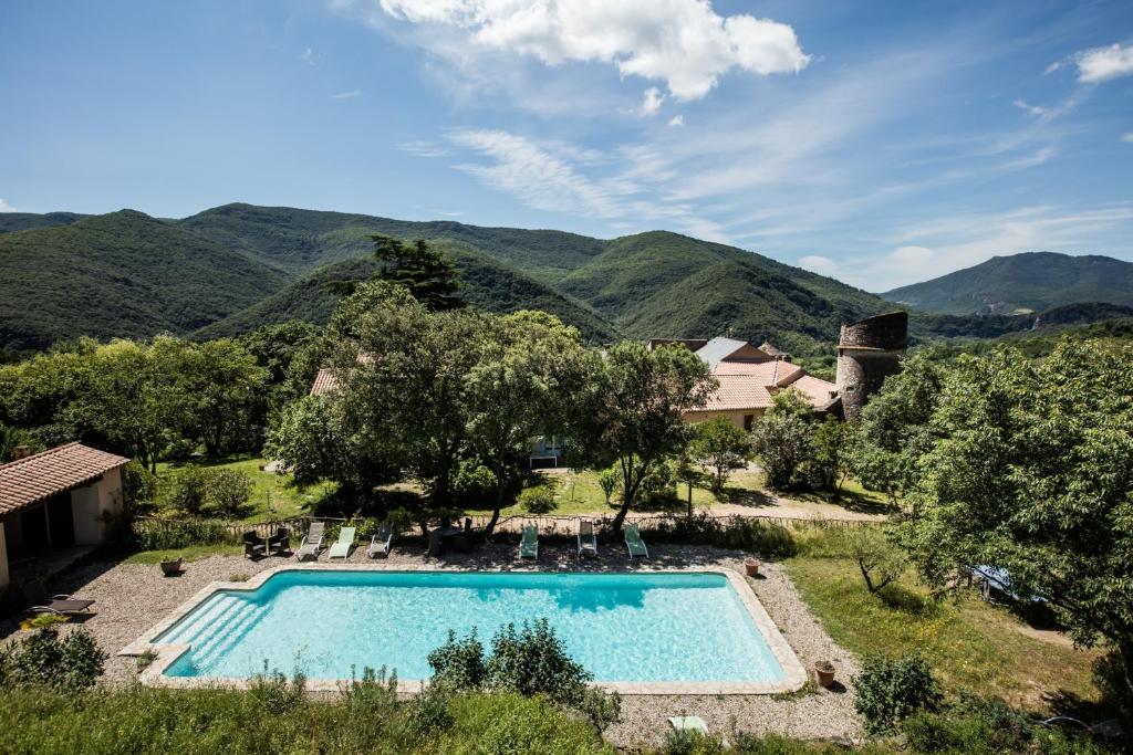 Colombières奥伯河畔的科伦比埃尔城堡酒店的一座室外游泳池,其背景为山脉