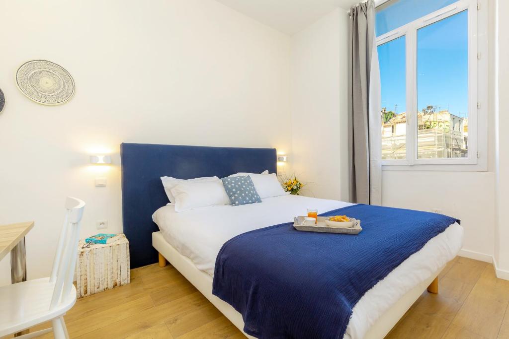 马赛布里德耶 - 老港公寓的卧室配有蓝色和白色的床和窗户。