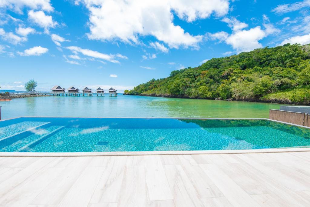 科罗尔The Pristine Villas and Bungalows at Palau Pacific Resort的享有水景的无边泳池