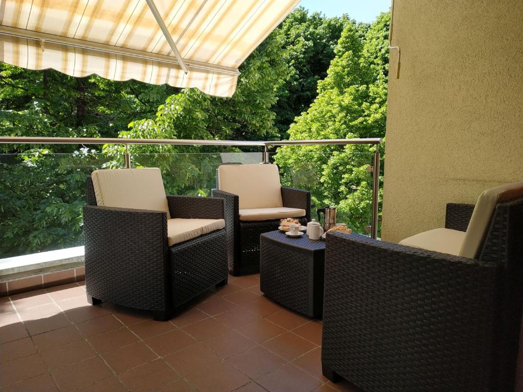 梅拉诺Appartment Trojer的庭院配有桌椅和窗户。