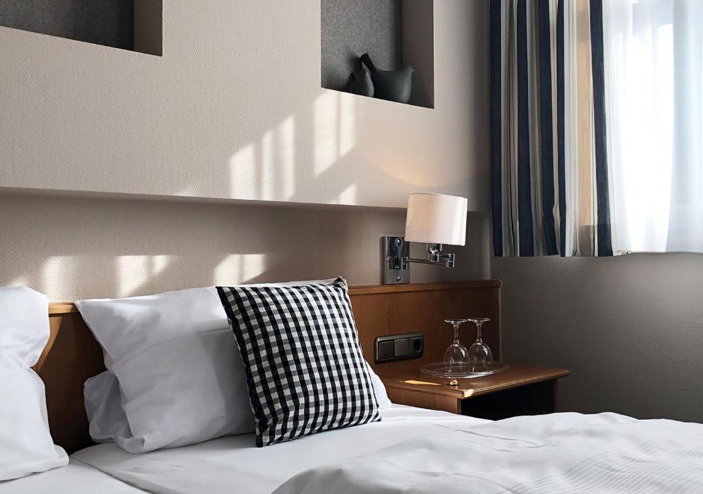 施韦因福特Mangolds Boutique Hotel & Fruehstuecksmeisterei的一间卧室配有一张带白色床单的床和一扇窗户。