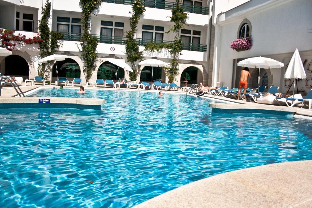 埃斯波森迪素雅唯马尔酒店的游泳池,在酒店内有工作人员