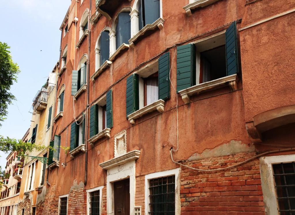 威尼斯Sweet Home New的一座带绿色百叶窗的古老红砖建筑