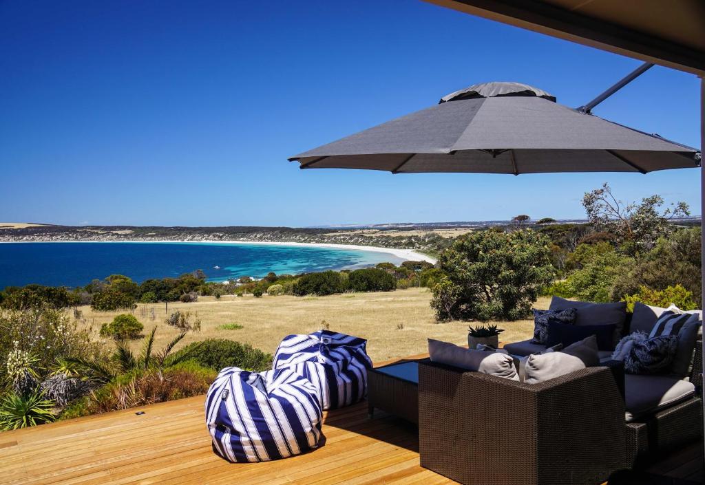 Emu BayThe Cape的一个带椅子和遮阳伞的庭院和大海