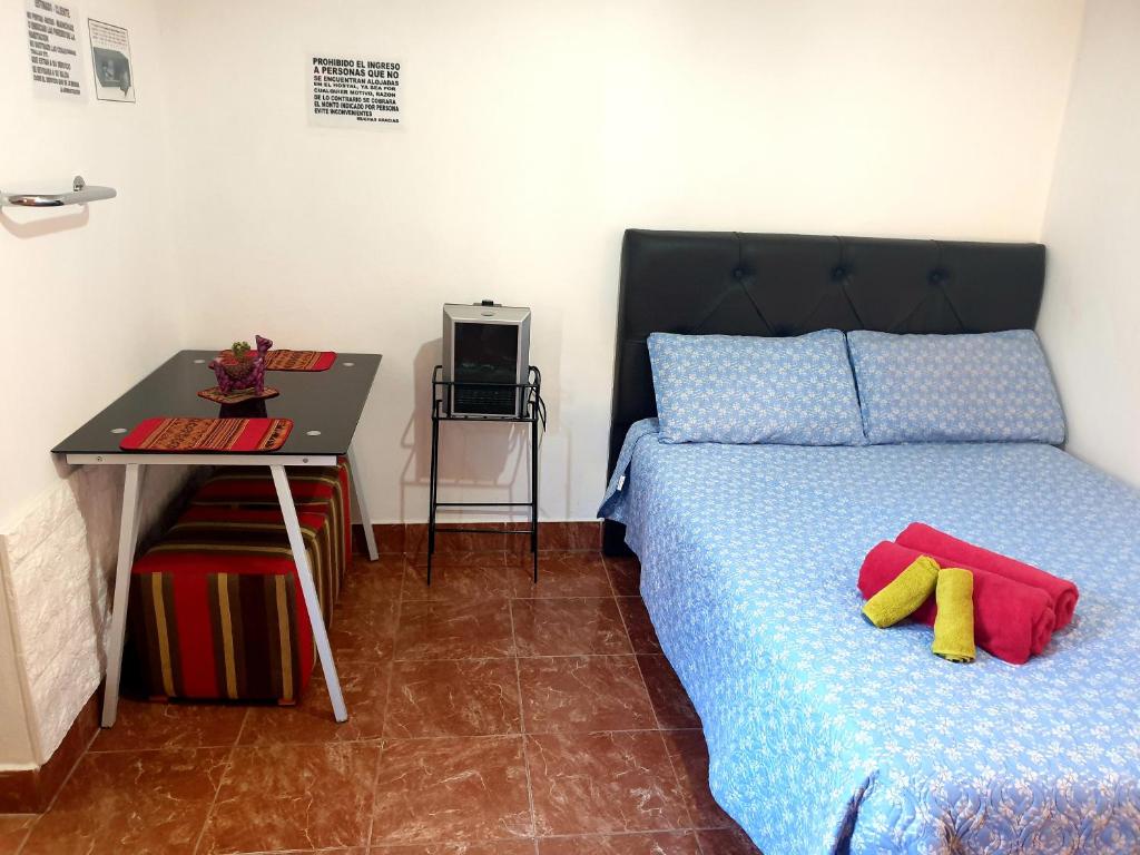 蒂尔卡拉Tilcara Hostal Niña Coya的一间卧室配有一张床、一张桌子和一张书桌