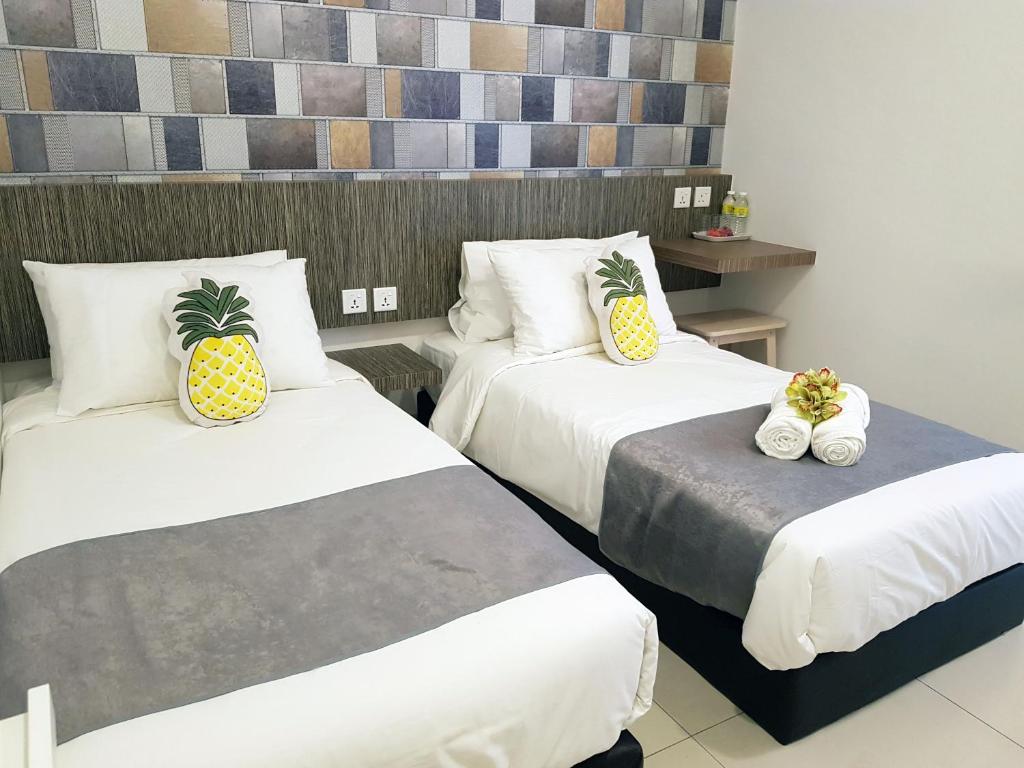 关丹Tas 96 Inn的两张位于酒店客房的床,配有 ⁇ 萝枕头