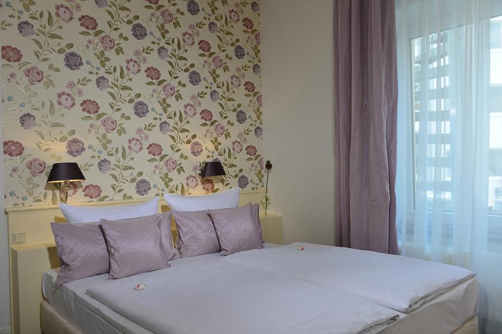 科隆多斯皮腾酒店的一间卧室配有一张带花卉壁纸的床