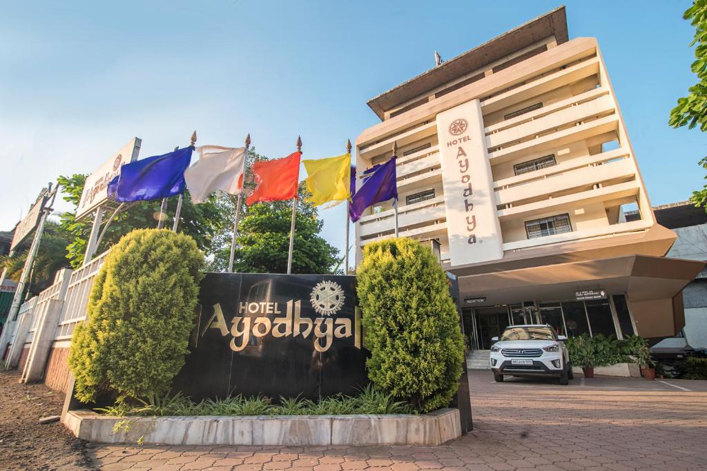 戈尔哈布尔Hotel Ayodhya的标志在有旗帜的建筑前方