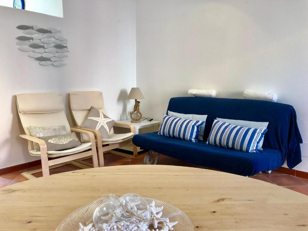 圣特雷莎加卢拉Il Gabbiano的客厅配有蓝色的沙发和椅子