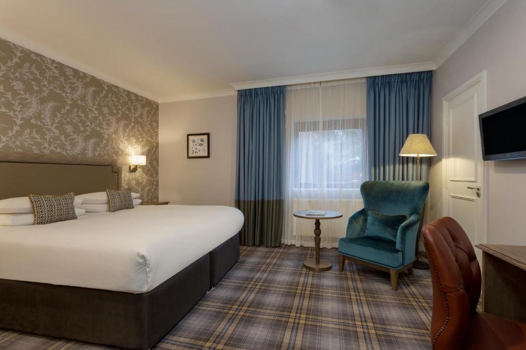 查塔姆Bridgewood Manor Hotel & Spa的酒店客房带大床和蓝椅