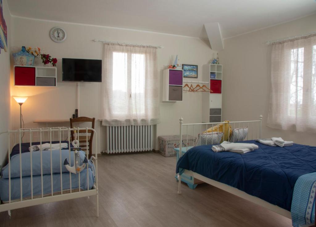法诺La Luna nel Parco的一间卧室设有两张床,墙上配有电视。
