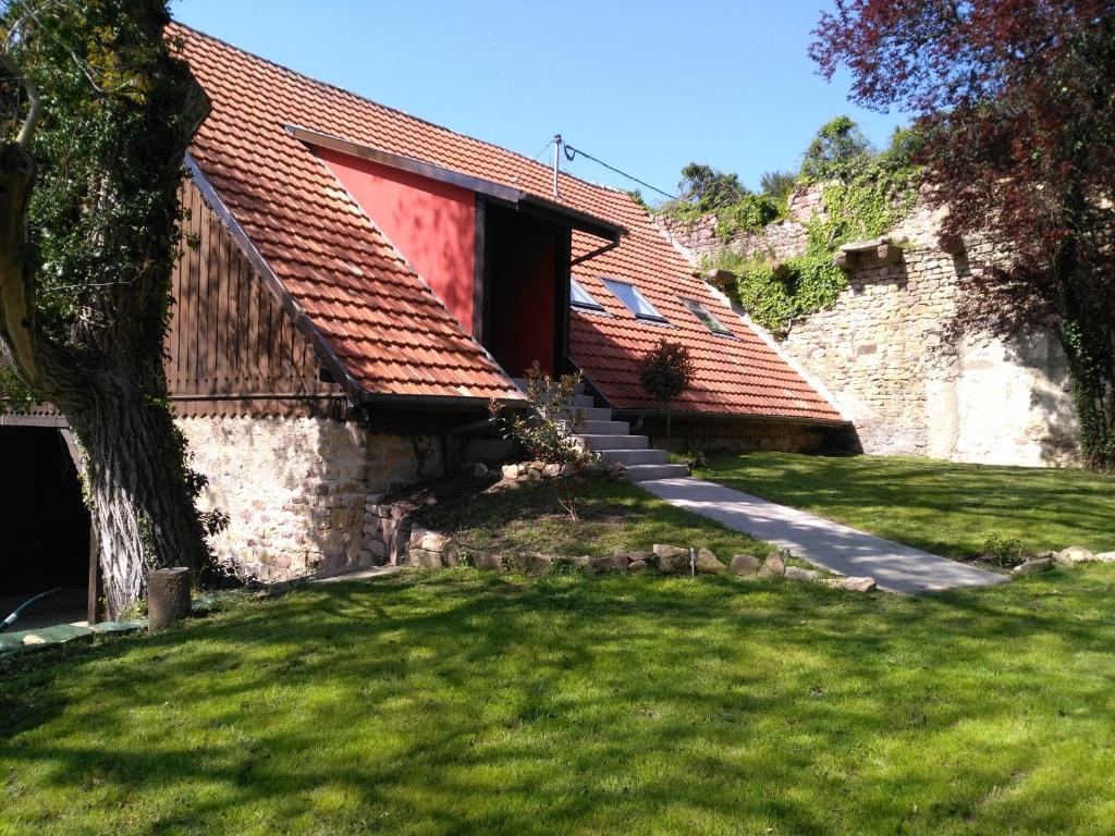 鲁法克Joli gîte F2 indépendant avec jardin privé的一座有红色屋顶和草地庭院的房子