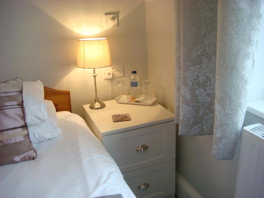 埃文河畔斯特拉特福Broadlands Guest House的一间卧室,配有一张床和床头灯