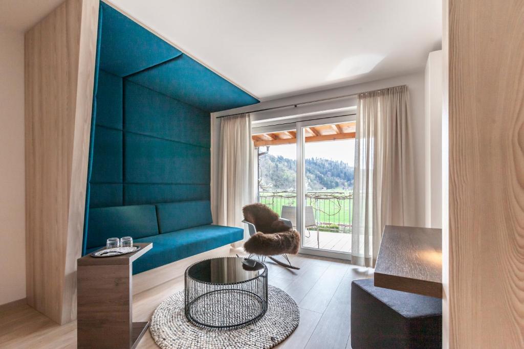 沃尔法赫Bollenhuthotel Kirnbacher Hof的客厅配有蓝色的沙发和桌子