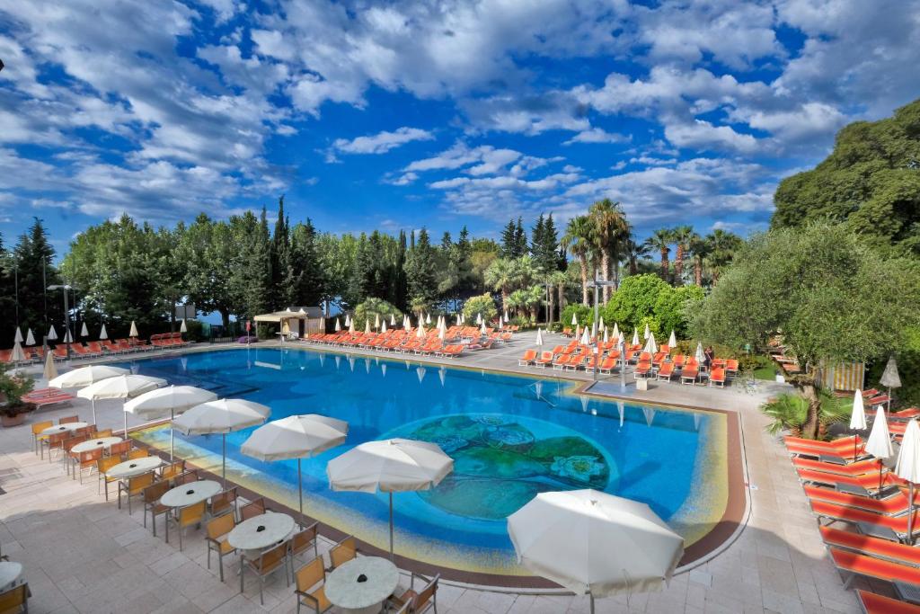 巴多利诺葛丽缇帕克酒店的一个带椅子和遮阳伞的大型游泳池