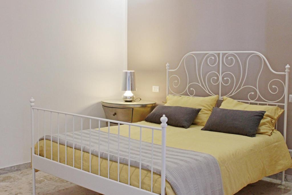 马泰拉I Tre Cardilli的一间卧室配有白色床和黄色枕头