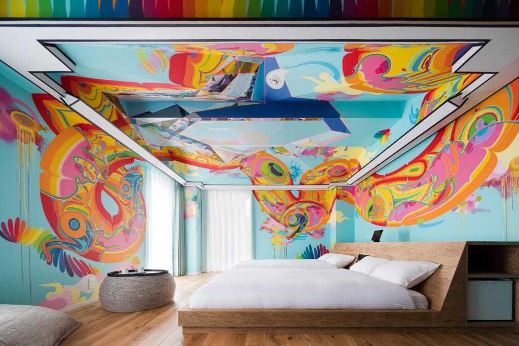 京都BnA Alter Museum的卧室的天花板上装饰有色彩缤纷的壁画