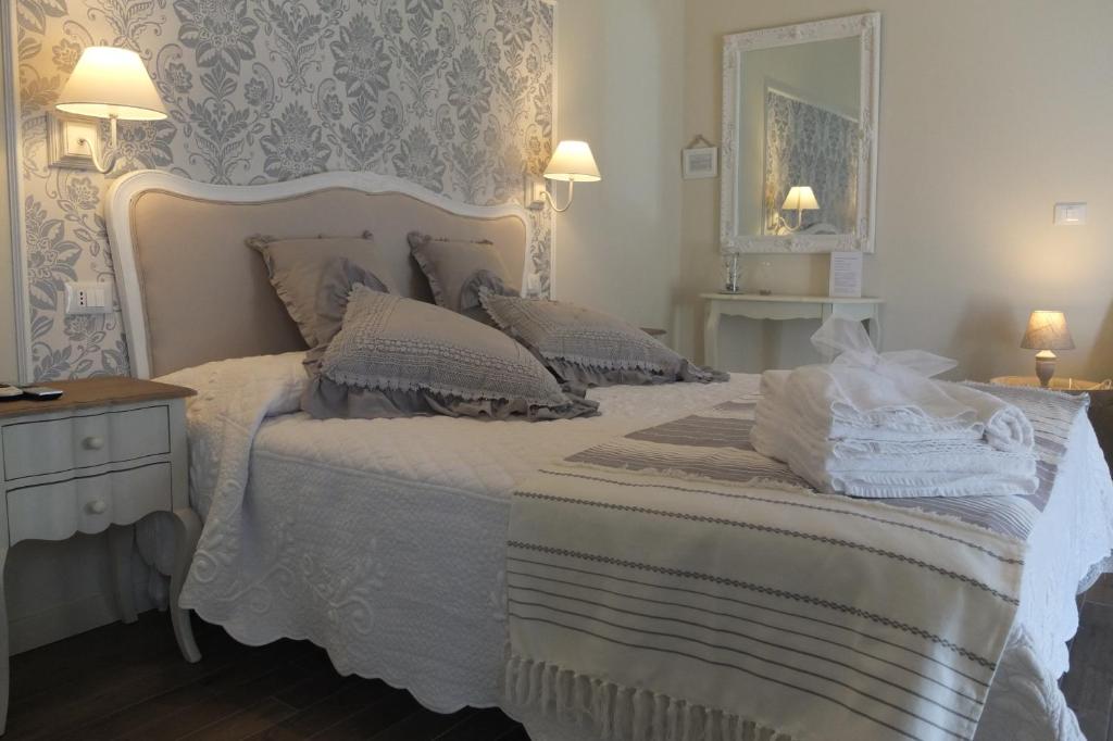 西尔米奥奈Romantic Home的卧室配有白色的床和镜子