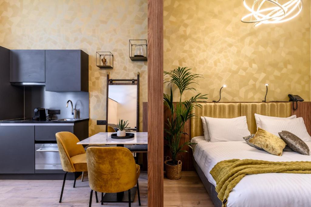 奥德纳尔德Leopold Hotel Oudenaarde的一间卧室配有一张床铺和一张桌子,还设有一间厨房