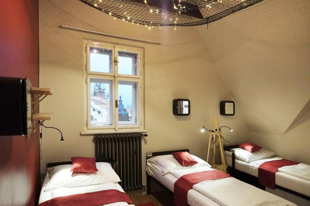 布拉格Czech Inn的带三张床和窗户的客房