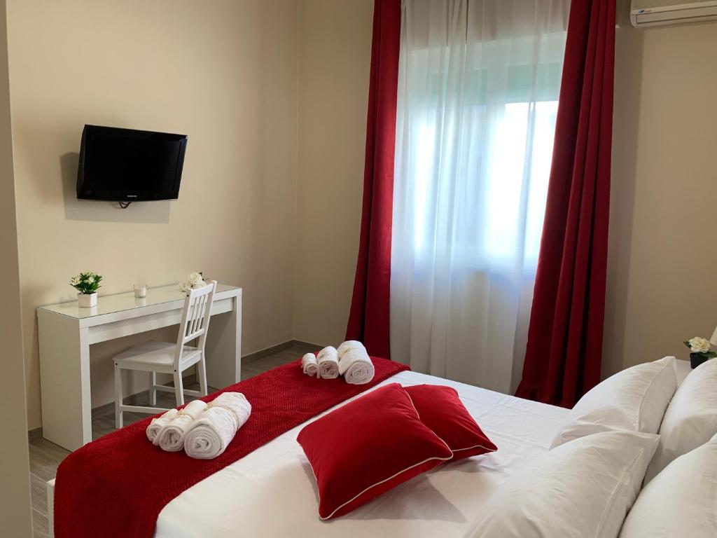 巴勒莫Casa Al Porto的一间卧室配有一张带红色窗帘的床和一张书桌