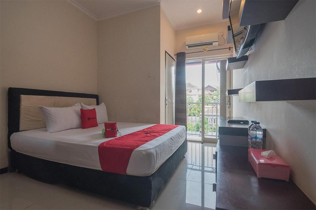 巴厘巴板RedDoorz near E Walk Mall Balikpapan的一间卧室设有一张床和一个大窗户