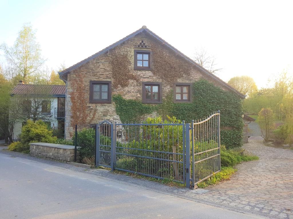 ManhayAncien moulin de Vaux Chavanne的前面有蓝色门的砖房